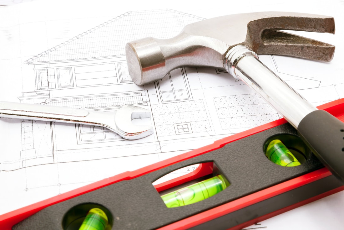 adu design plans with a hammer and wrench laying on top